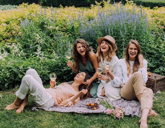 Négy barátnő nevetve piknikezik